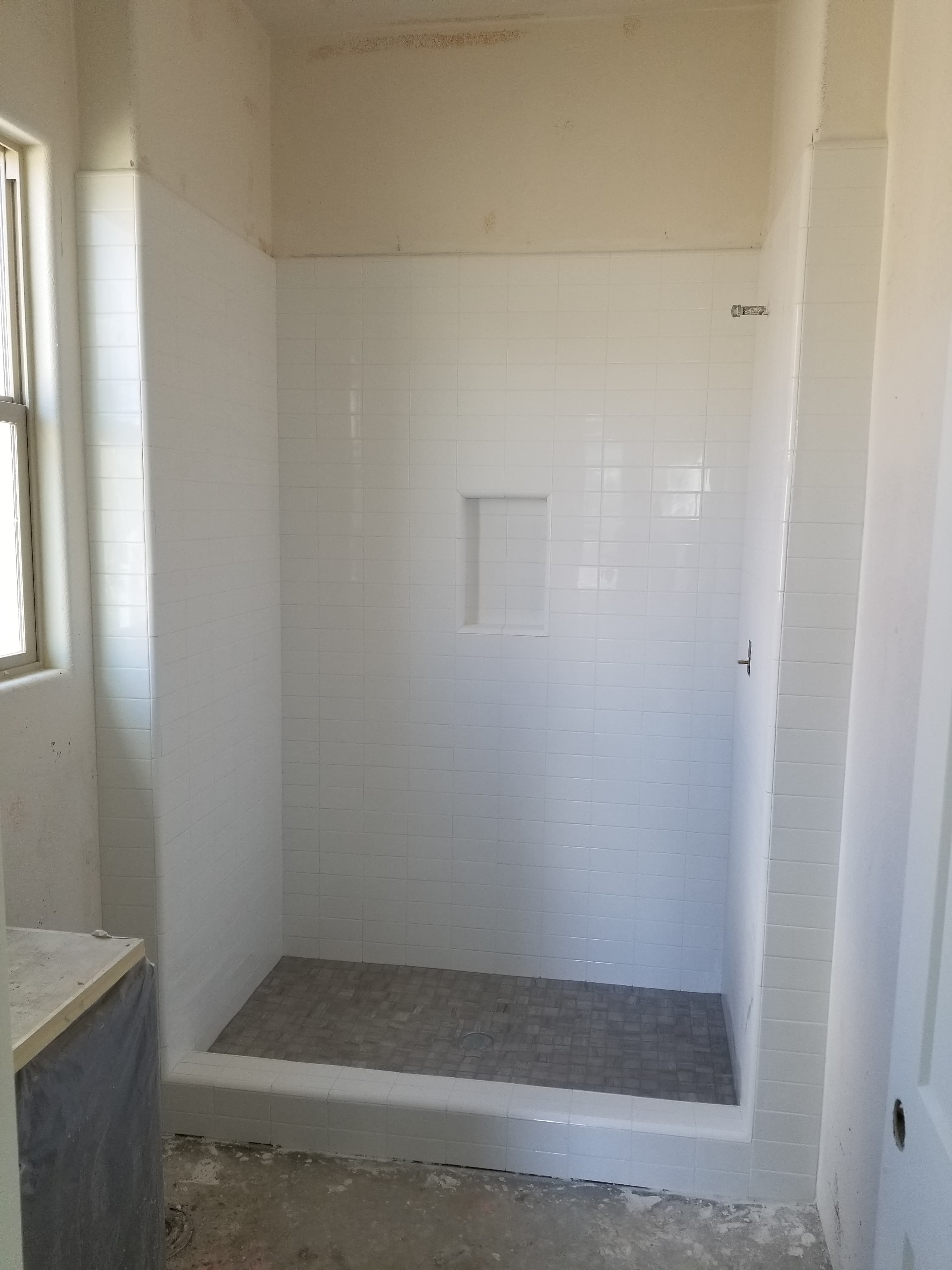 Early-stage La Quinta shower construction with waterproofing membrane visible on backing
