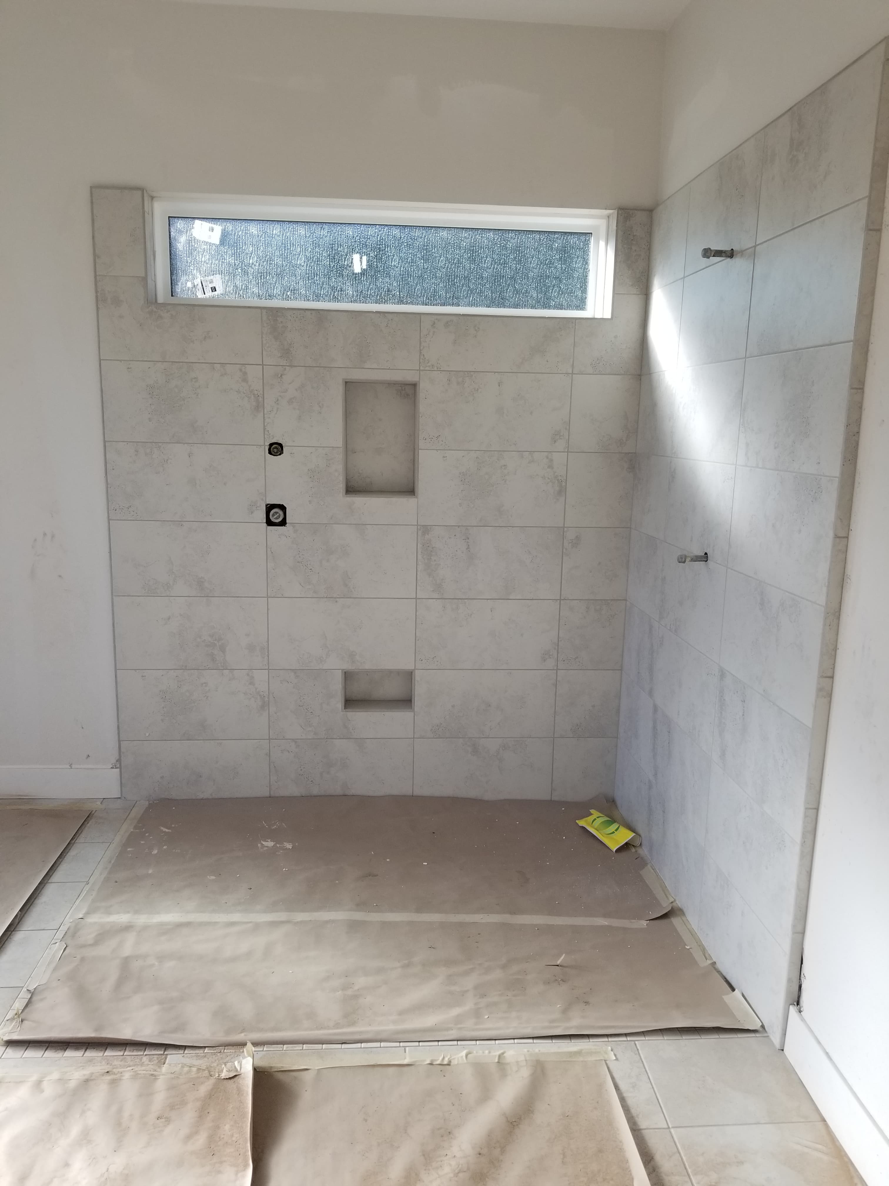 Modern La Quinta shower with gray cement tile backdrop and vertical glass window detail