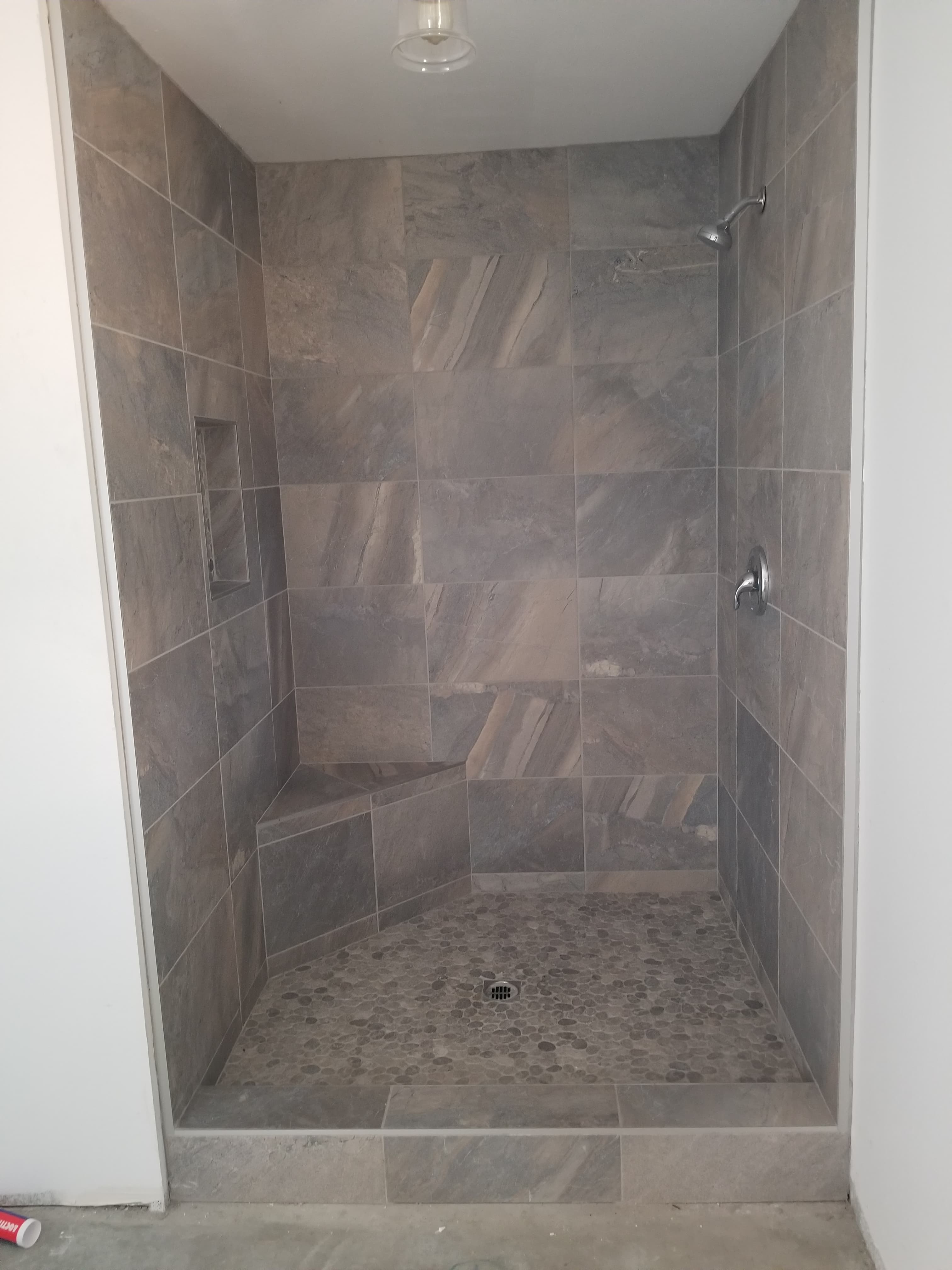 Luxury walk-in shower with gray marble and white subway tile in Menifee, CA