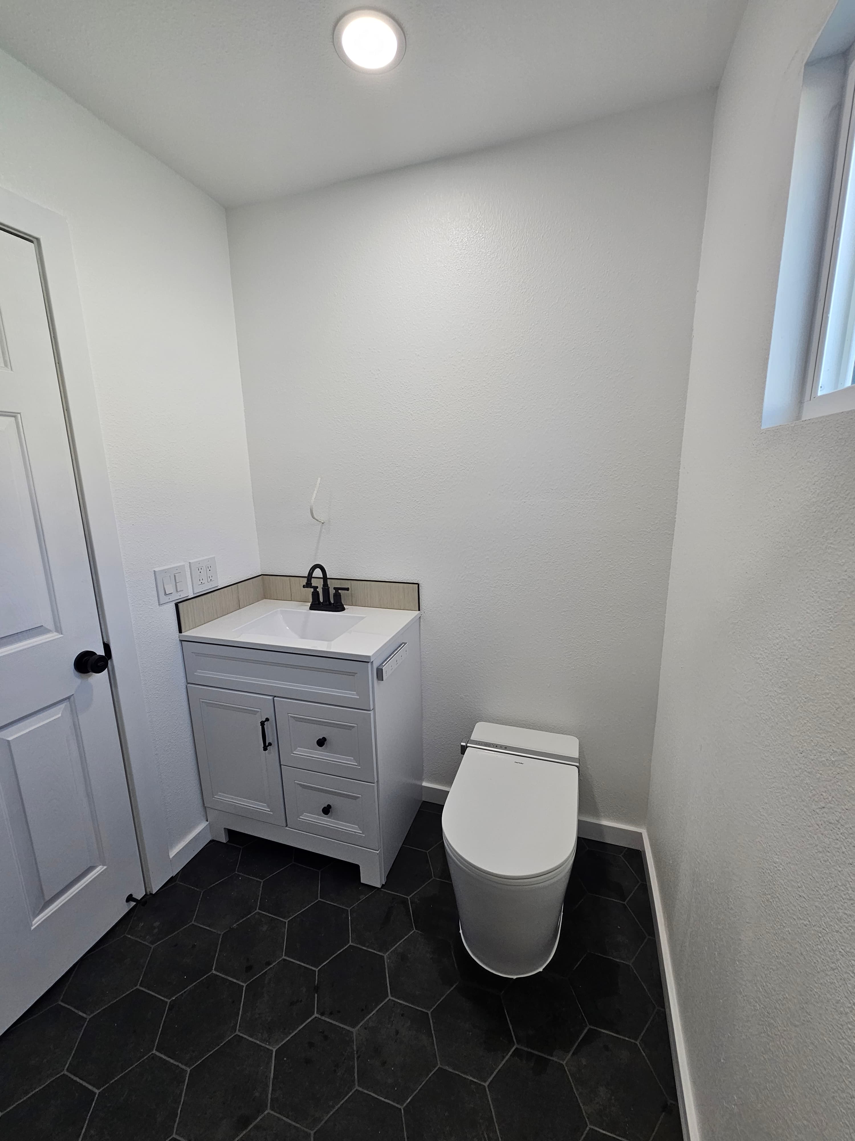 Sophisticated Riverside bathroom vanity with hexagonal tile flooring and clean white fixtures