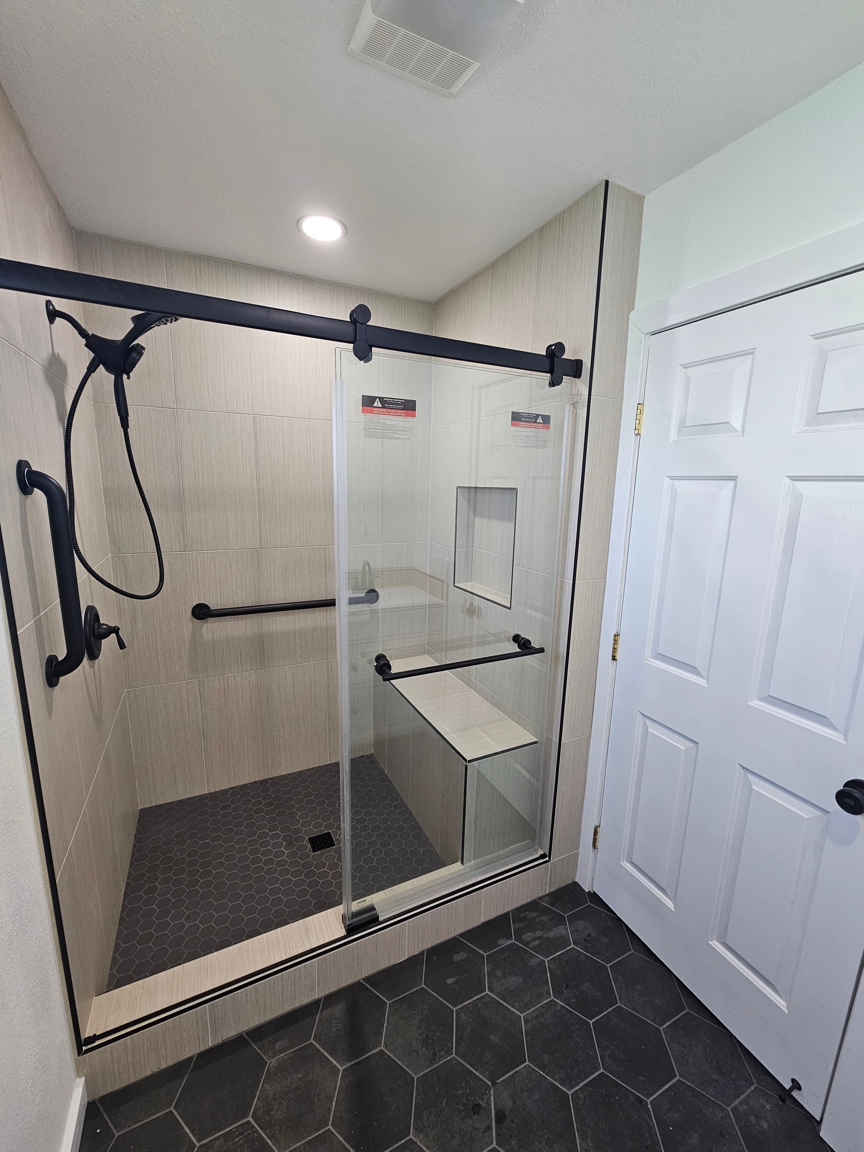 Luxury Riverside steam shower with contrasting linear and hexagon tile accents