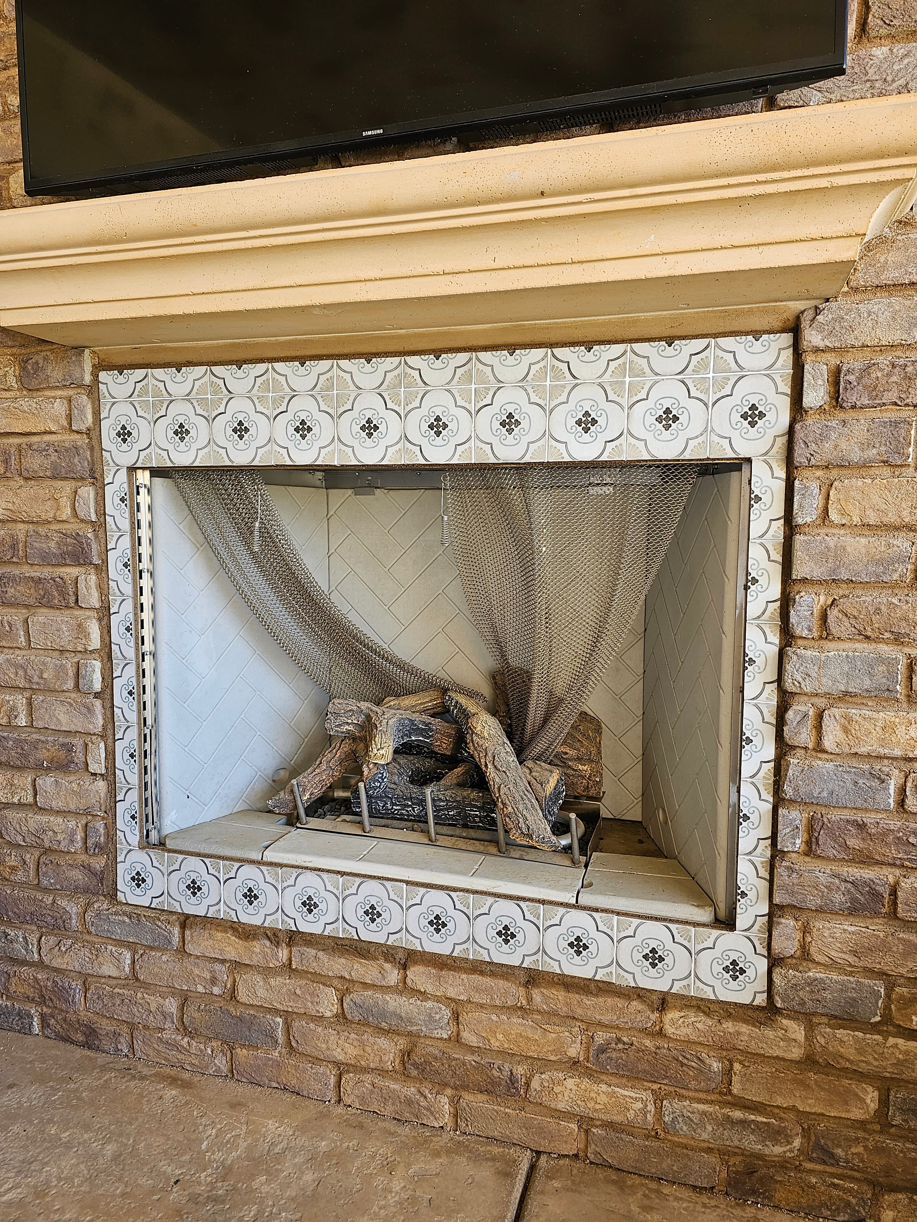Custom Temecula fireplace surround with ornate white and gray patterned tile frame