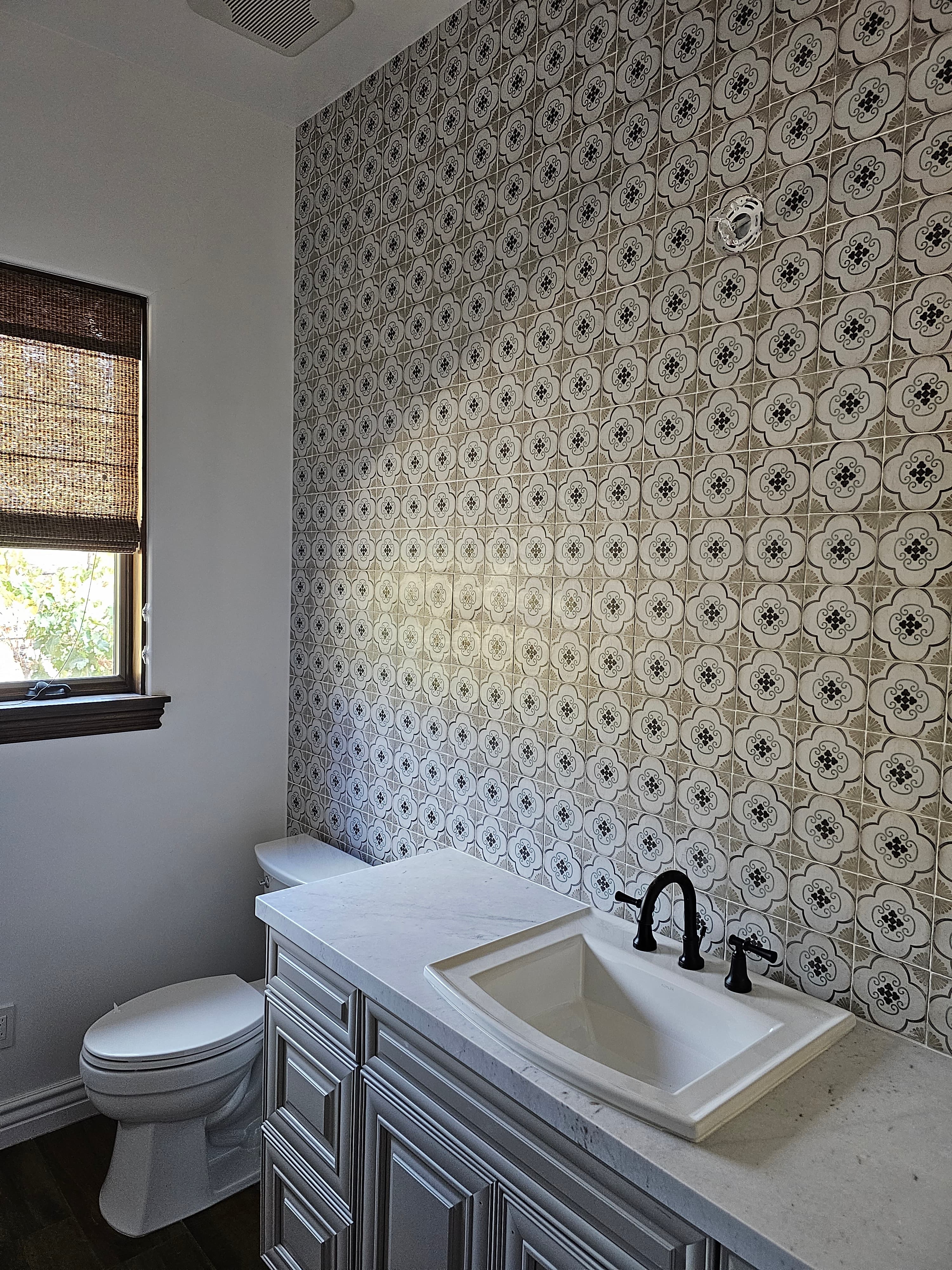 Temecula bathroom floor with intricate white and gray geometric patterned tile