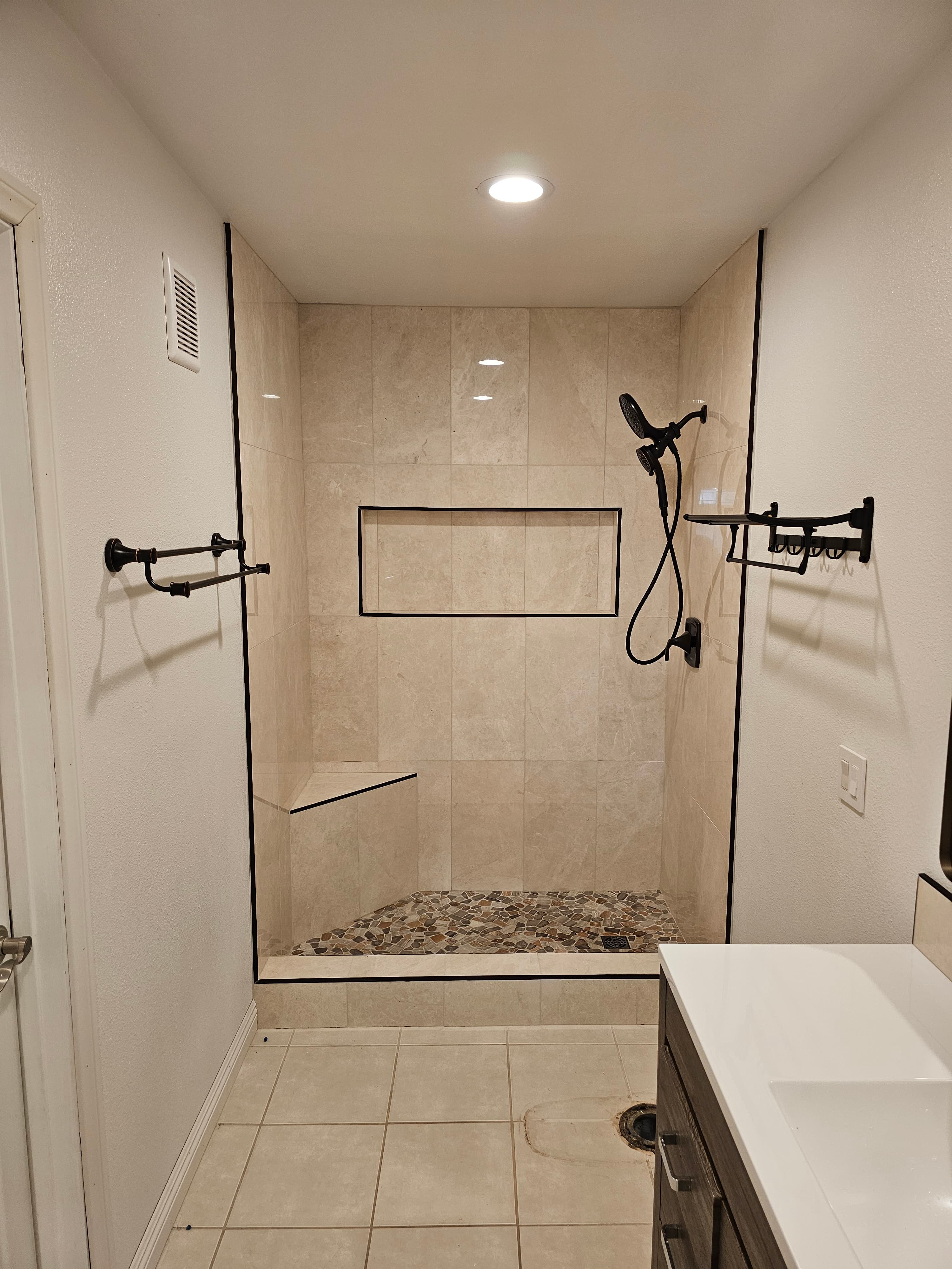 Spa-like Yorba Linda walk-in shower featuring travertine and mosaic tile accents